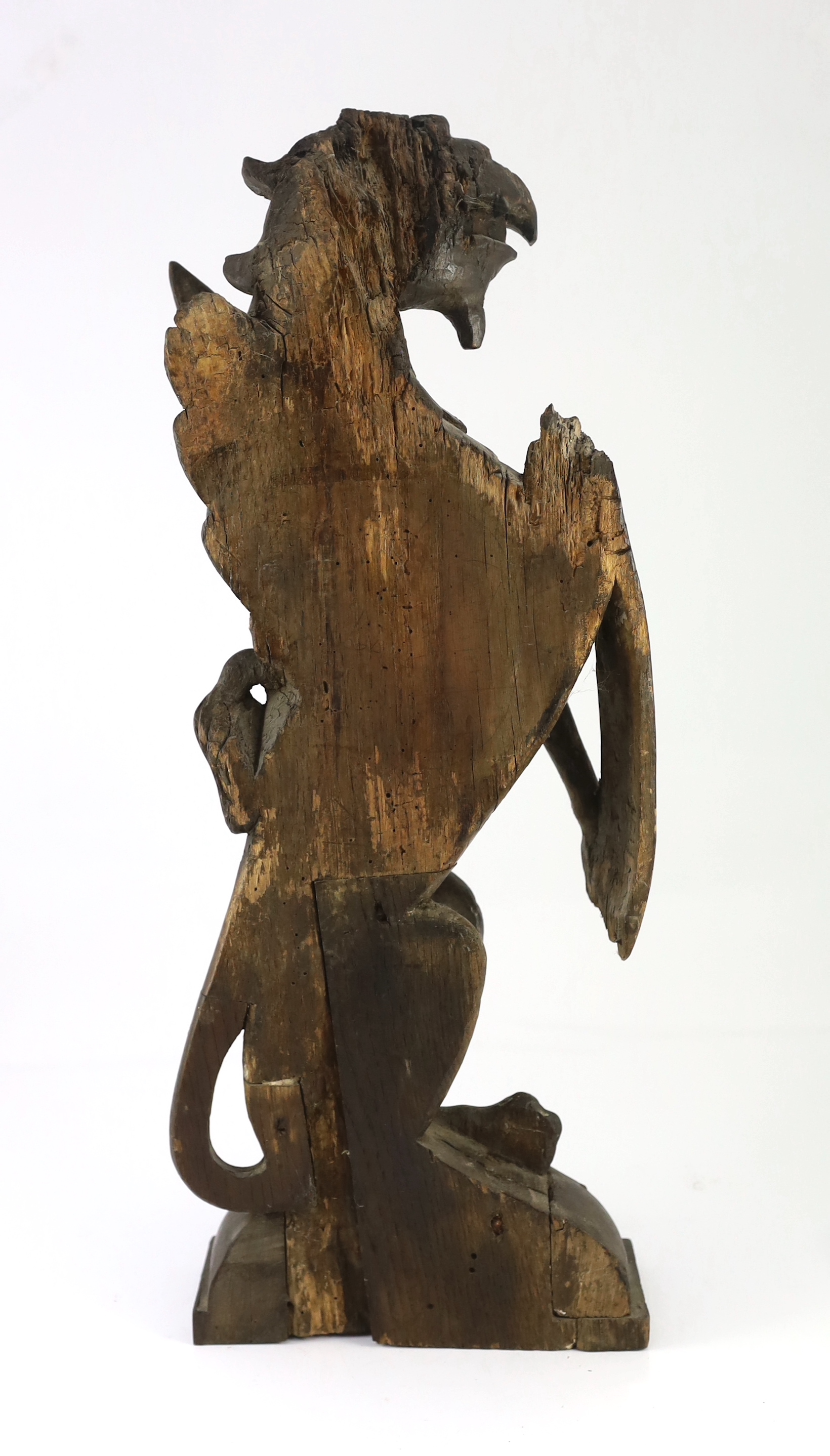 A 16th century Dutch carved oak model of a griffin rampant holding a shield